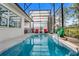 Refreshing screened pool is perfect for outdoor relaxation, complete with lounge chairs and a convenient grilling area at 14366 Alafaya Oak Bnd, Orlando, FL 32828