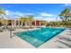 Community pool with a well maintained deck, sun loungers, palm trees and building in the background at 14366 Alafaya Oak Bnd, Orlando, FL 32828
