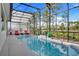 Sparkling screened pool is surrounded by tropical landscaping, with a grilling area and cozy lounge chairs at 14366 Alafaya Oak Bnd, Orlando, FL 32828