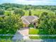 Aerial view of a well-maintained home with lush landscaping, a brick driveway, and a spacious front lawn at 1862 Lorenzo Ln, Oviedo, FL 32765