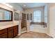 Bathroom featuring a glass-enclosed shower, soaking tub, tile flooring, and wood cabinets at 1862 Lorenzo Ln, Oviedo, FL 32765