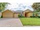 Charming single-Gathering home featuring a manicured front yard, brick driveway, and a spacious three-car garage at 1862 Lorenzo Ln, Oviedo, FL 32765