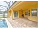 Covered patio with brick flooring, sliding glass doors and view of the pool and backyard at 1862 Lorenzo Ln, Oviedo, FL 32765