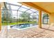 In-ground pool surrounded by a screened enclosure and a well-manicured backyard at 1862 Lorenzo Ln, Oviedo, FL 32765