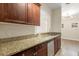 Kitchen featuring granite countertops, stainless steel appliances, and wood cabinetry at 191 Villa Di Este Ter # 201, Lake Mary, FL 32746