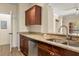 Cozy kitchen with wood cabinets, granite countertops, and stainless steel appliances at 191 Villa Di Este Ter # 201, Lake Mary, FL 32746