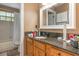 Bathroom showcasing a granite countertop, wooden cabinets, and tub with shower and curtain at 1910 Palm View Dr, Apopka, FL 32712