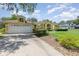 Inviting one-story home featuring an attached garage, large driveway and manicured front lawn at 1910 Palm View Dr, Apopka, FL 32712