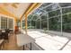 A spacious screened patio with ample seating and a neutral-colored tile floor at 1910 Palm View Dr, Apopka, FL 32712
