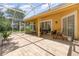 A spacious screened patio with ample seating and a neutral-colored tile floor at 1910 Palm View Dr, Apopka, FL 32712