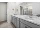 Bright bathroom features double sinks, light gray cabinets, white countertops, and a glass door shower at 1999 Tropical Palms Cir, Kissimmee, FL 34747