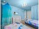 Charming bedroom features a mural, chandelier lighting, and twin beds with matching decor at 1999 Tropical Palms Cir, Kissimmee, FL 34747