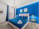 Vibrant bedroom showcasing a bright blue accent wall, plush bedding, and stylish decor at 1999 Tropical Palms Cir, Kissimmee, FL 34747