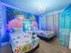 Charming bedroom with a mural, chandelier lighting, and twin beds with matching decor at 1999 Tropical Palms Cir, Kissimmee, FL 34747