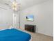A well-lit bedroom featuring a TV, dresser, and view of an ensuite bathroom at 1999 Tropical Palms Cir, Kissimmee, FL 34747