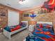 This themed bedroom features brick design wall paneling, and two twin beds with themed decor at 1999 Tropical Palms Cir, Kissimmee, FL 34747