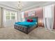 Beautiful bedroom with a gray bed frame, teal bedspread, red pillows, and modern chandelier at 1999 Tropical Palms Cir, Kissimmee, FL 34747