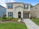 Charming two-story home featuring a well-maintained yard, neutral paint, and an attached one-car garage at 1999 Tropical Palms Cir, Kissimmee, FL 34747