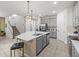 Spacious kitchen featuring an island with counter seating, gray cabinets, and a seamless transition to the living spaces at 1999 Tropical Palms Cir, Kissimmee, FL 34747