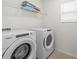 Bright laundry room with washer, dryer, and shelving for storage at 1999 Tropical Palms Cir, Kissimmee, FL 34747