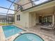Backyard pool and hot tub with screened-in patio and outdoor seating at 1999 Tropical Palms Cir, Kissimmee, FL 34747
