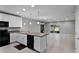 Open kitchen with white cabinets, black appliances and access to the living room at 228 Primrose Dr, Davenport, FL 33837