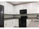 Modern kitchen with white cabinetry, black appliances, and ample counter space at 228 Primrose Dr, Davenport, FL 33837