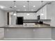 Well-lit kitchen with white cabinets, black appliances, and breakfast bar at 228 Primrose Dr, Davenport, FL 33837