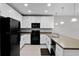 Modern kitchen with white cabinets, black appliances, and spacious countertop at 228 Primrose Dr, Davenport, FL 33837