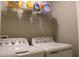 Neat laundry room featuring washer, dryer, and shelves at 228 Primrose Dr, Davenport, FL 33837