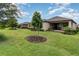 This backyard boasts an expansive lawn, mature trees, and a covered patio for outdoor enjoyment at 2342 Clemblue Rd, Clermont, FL 34715