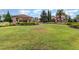 Lush green lawn with tropical landscaping in front of neighborhood building with terracotta tile roof at 2342 Clemblue Rd, Clermont, FL 34715