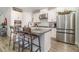 Bright kitchen with stainless steel appliances, granite countertops, white cabinets, and center island seating at 2342 Clemblue Rd, Clermont, FL 34715