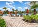 A community pool is surrounded by palm trees and lounge chairs and features several orange canopies at 2342 Clemblue Rd, Clermont, FL 34715