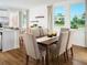 Bright dining area with hardwood floors, a wooden table, and expansive windows overlooking a lush landscape at 2782 Virginia Pine Dr, Bartow, FL 33830