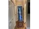Well-lit hallway with multiple doors, wood flooring, and view of decorative cabinets at 2808 Manatee Rd, Tavares, FL 32778