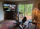 Cozy room with an exercise bike, TV, and sliding glass door to the outdoor deck at 2808 Manatee Rd, Tavares, FL 32778