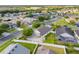 A high angle view of a house with a well-kept lawn in a neighborhood with lots of trees and other houses at 2830 Alton Dr, Kissimmee, FL 34741