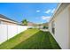This fenced backyard features a well-maintained lawn, newly planted palm tree, and brick hardscape at 2830 Alton Dr, Kissimmee, FL 34741