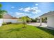 A fully fenced backyard with vibrant green grass, complimented with a young palm tree and attractive brickwork at 2830 Alton Dr, Kissimmee, FL 34741