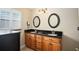 Bathroom featuring double vanity with dark granite counters and wood cabinets at 2830 Alton Dr, Kissimmee, FL 34741