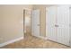 Neutral bedroom featuring tile flooring, white trim, closet, and open doorway at 2830 Alton Dr, Kissimmee, FL 34741