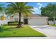 Charming single-story home features a well-manicured lawn, a two car garage and a beautiful palm tree at 2830 Alton Dr, Kissimmee, FL 34741