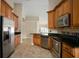 Kitchen featuring stainless appliances, wood cabinets, and seamless flow to dining area at 2830 Alton Dr, Kissimmee, FL 34741