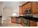 Kitchen with stainless appliances, black countertops and warm wood cabinetry at 2830 Alton Dr, Kissimmee, FL 34741