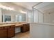 Elegant bathroom featuring a large mirror, double sinks, and a tiled shower enclosure at 3223 Blazing Star Ln, Harmony, FL 34773