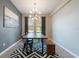Sunlit dining room with a modern chandelier, black chairs, and a bold geometric rug at 3223 Blazing Star Ln, Harmony, FL 34773