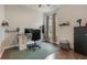 A functional home office boasts hardwood floors, a full desk setup, and a storage unit, creating an organized workspace at 3223 Blazing Star Ln, Harmony, FL 34773