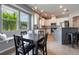 Sunlit eat-in kitchen with a breakfast nook, white cabinets, gray accents, and stainless steel appliances at 3223 Blazing Star Ln, Harmony, FL 34773