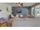 Cozy living room with a ceiling fan, comfortable seating, and a tranquil accent wall at 3223 Blazing Star Ln, Harmony, FL 34773
